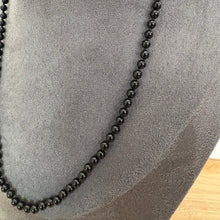 Load image into Gallery viewer, A long strand of glossy black round beads, a black agate necklace, displayed on a grey velvet jewellery bust.