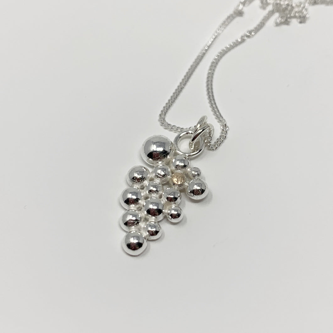Sterling silver pendant offset with a singular 9ct gold bead. The pendant sits on a sterling silver curb chain and has a high polished finish.